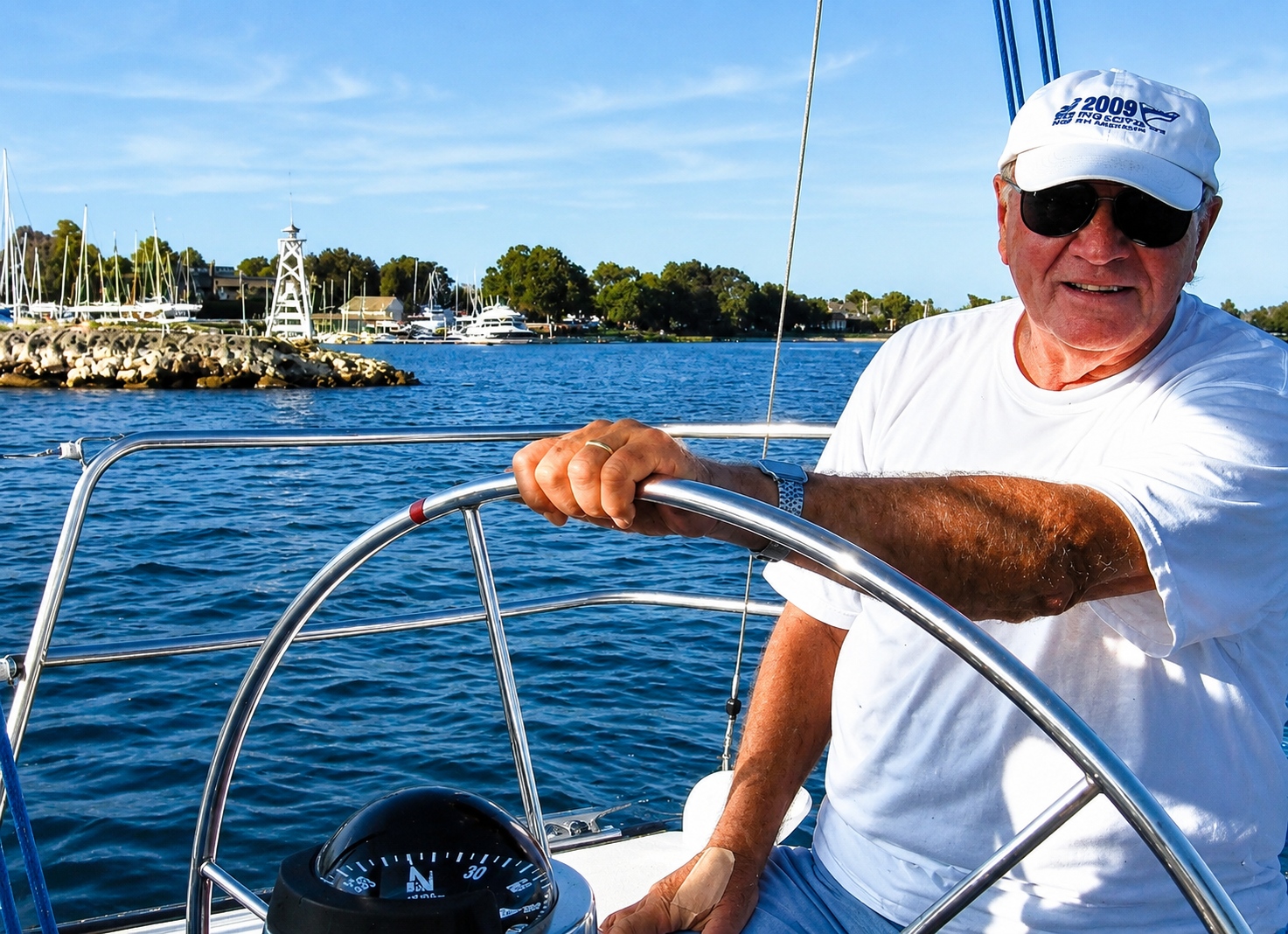 Jack Progelhof at the helm of a sailboat on the water